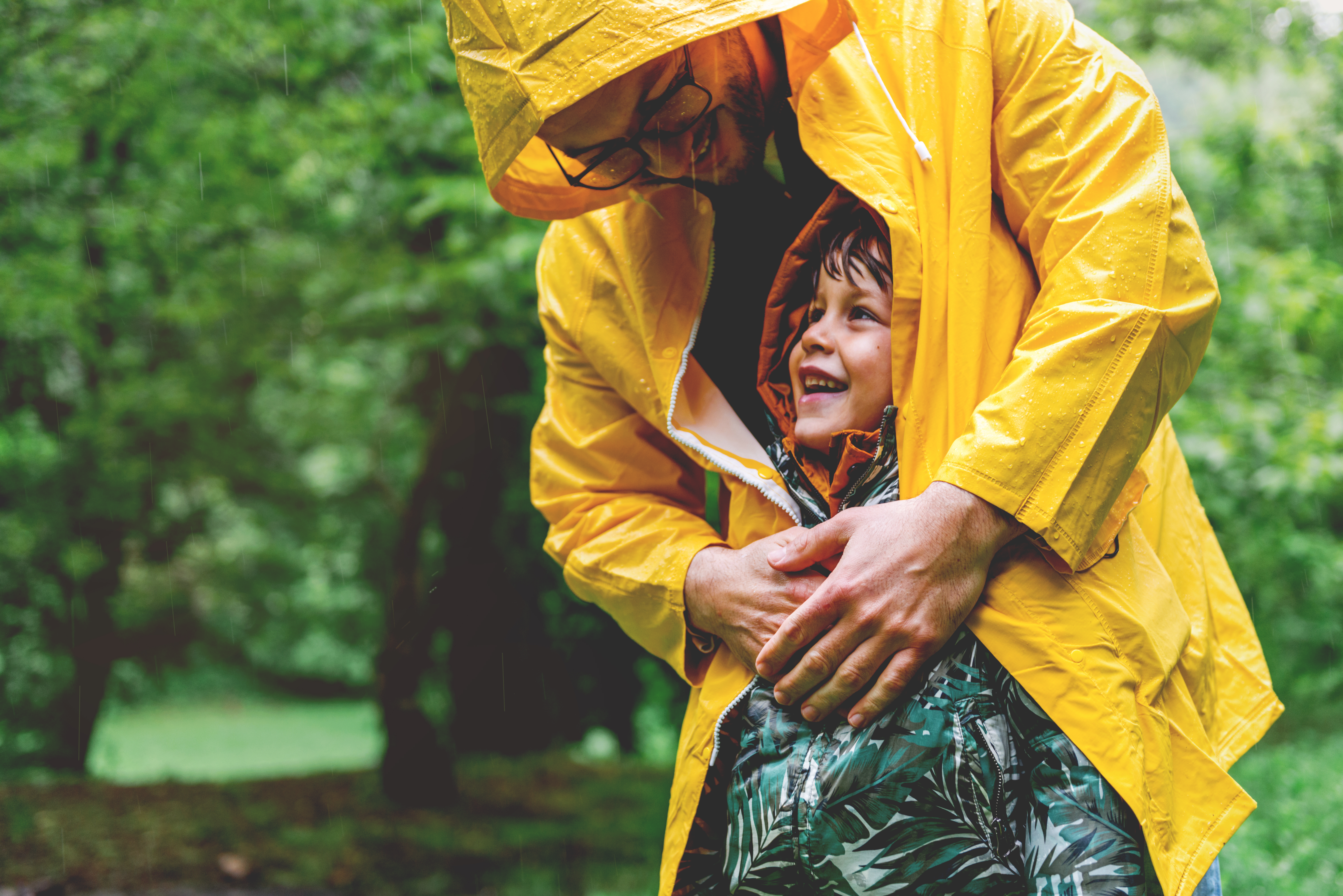 parent and child on rainy day in forest